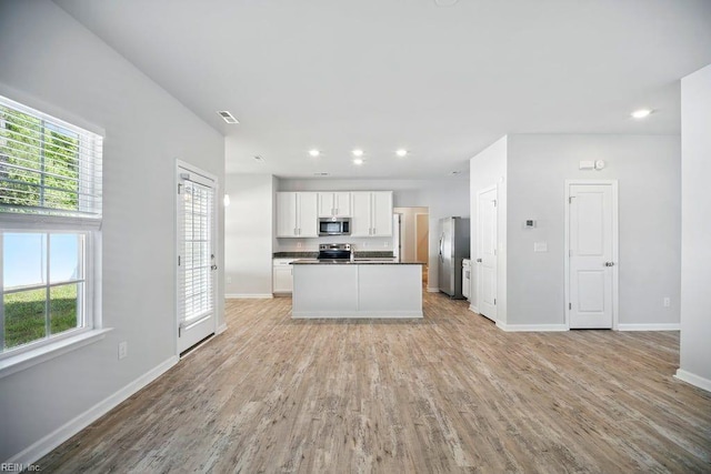 kitchen featuring open floor plan, a healthy amount of sunlight, and appliances with stainless steel finishes