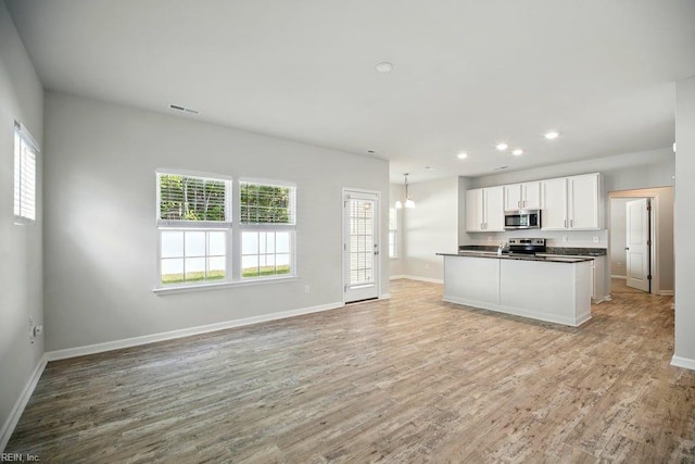 kitchen with dark countertops, white cabinetry, stainless steel appliances, and baseboards