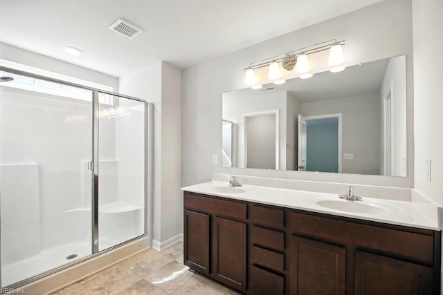 bathroom featuring double vanity, visible vents, a shower stall, and a sink