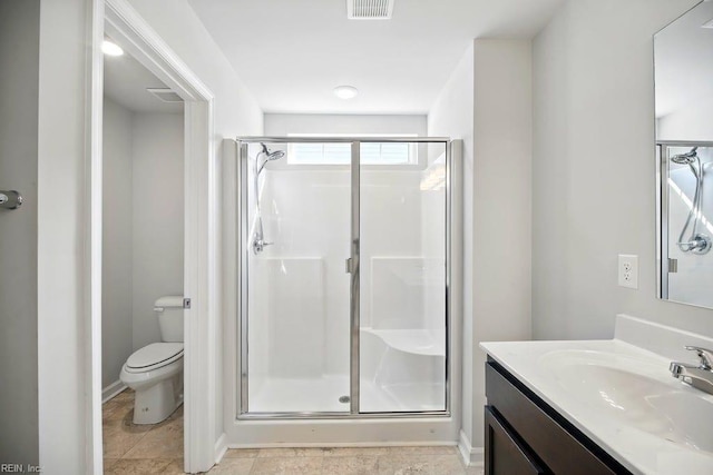bathroom with vanity, toilet, a shower stall, and visible vents