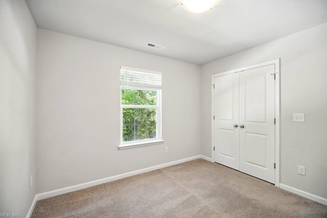 unfurnished bedroom with carpet floors, baseboards, and a closet