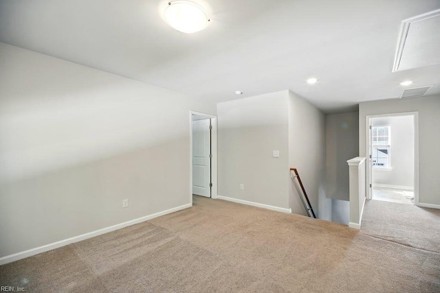 spare room featuring attic access, visible vents, baseboards, and carpet