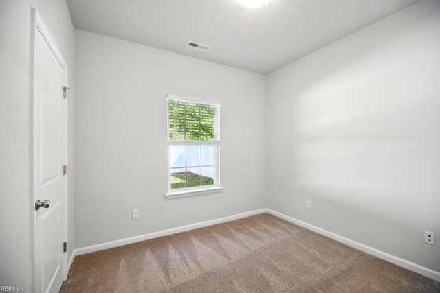 carpeted spare room featuring visible vents and baseboards