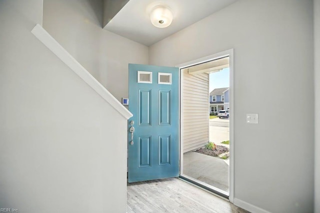 entryway featuring stairway, wood finished floors, and baseboards