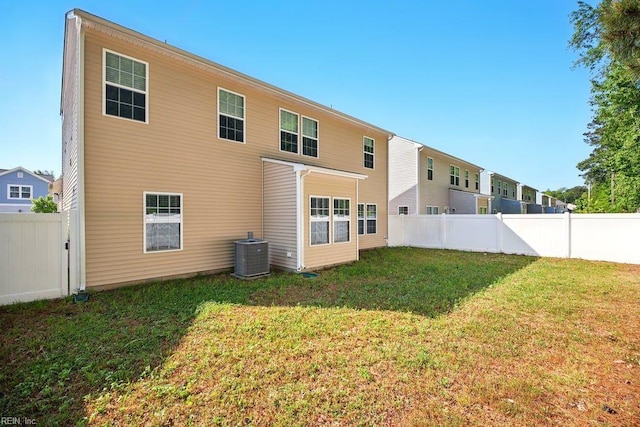 rear view of house with a yard, cooling unit, and a fenced backyard