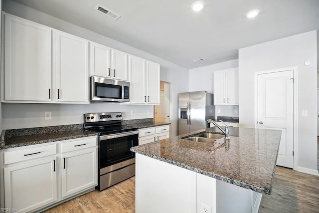 kitchen featuring light wood-type flooring, stainless steel appliances, visible vents, and a sink