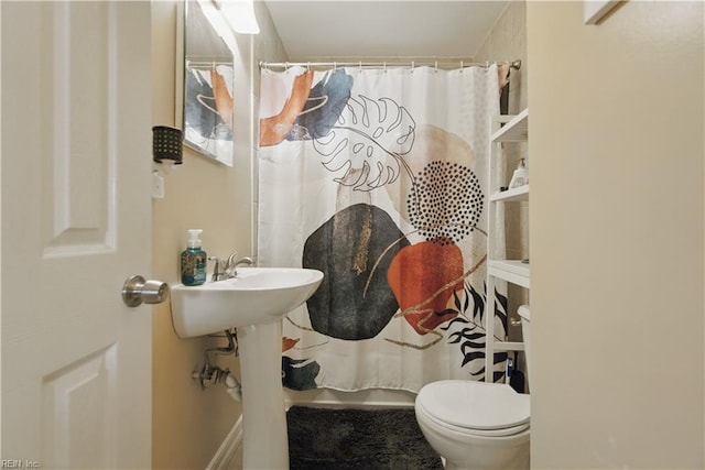 bathroom with toilet and a shower with curtain