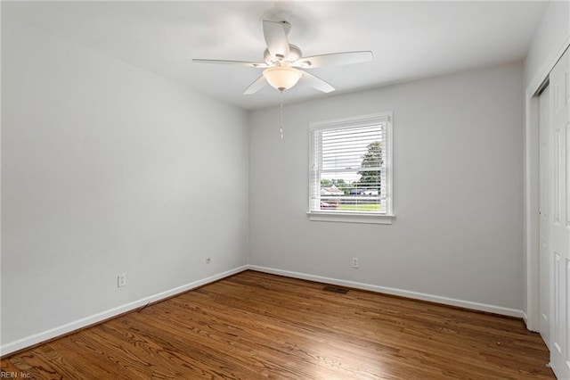 unfurnished bedroom featuring wood finished floors, a closet, and baseboards