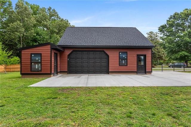 view of front of property featuring an attached garage, roof with shingles, concrete driveway, and an outdoor structure
