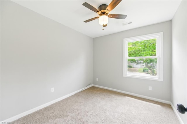 empty room featuring carpet, visible vents, baseboards, and a ceiling fan