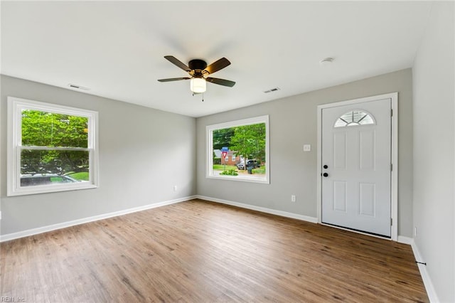 entryway with a wealth of natural light, visible vents, wood finished floors, and baseboards
