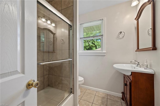 bathroom featuring toilet, enclosed tub / shower combo, tile patterned floors, baseboards, and vanity