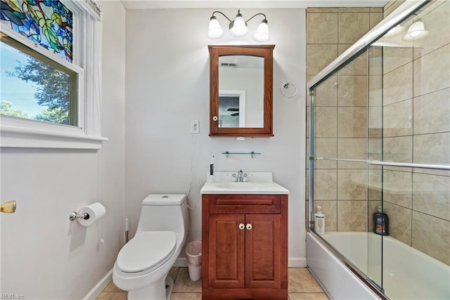 bathroom featuring toilet, enclosed tub / shower combo, baseboards, and tile patterned flooring
