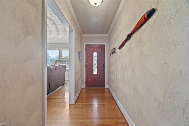 doorway to outside featuring crown molding, light wood-style floors, and baseboards