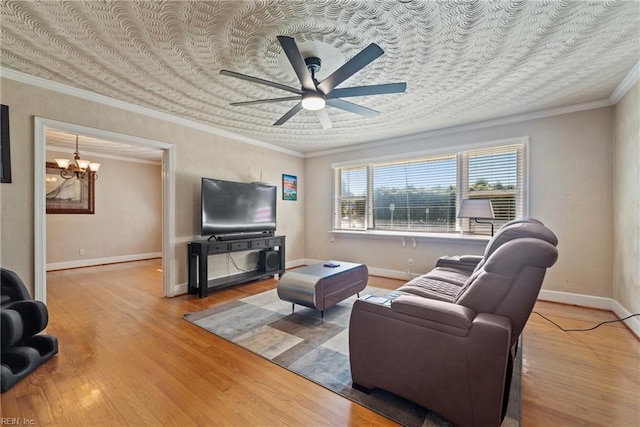living room featuring baseboards, crown molding, ceiling fan with notable chandelier, and wood finished floors