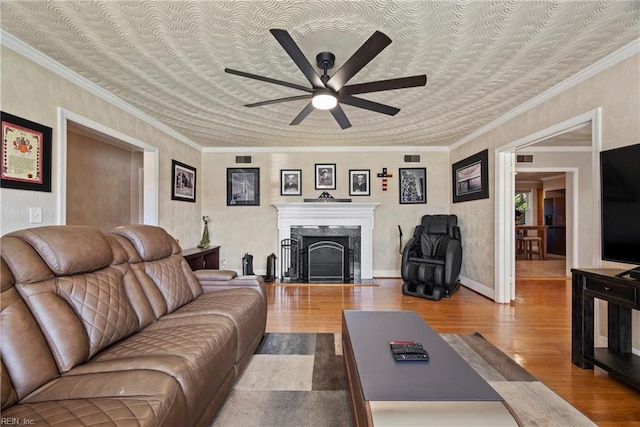 living area featuring ceiling fan, a high end fireplace, and wood finished floors