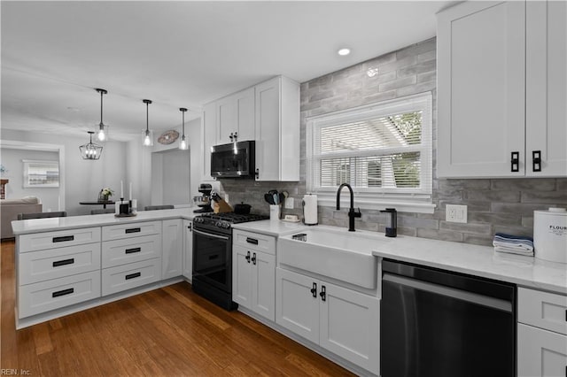 kitchen with dishwasher, gas range, a sink, stainless steel microwave, and a peninsula