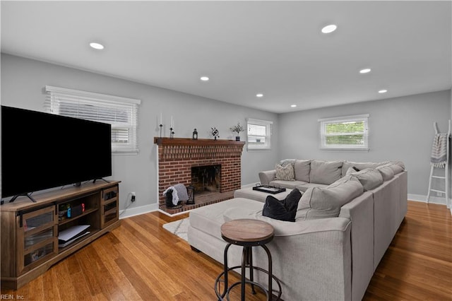 living area with recessed lighting, wood finished floors, baseboards, and a fireplace