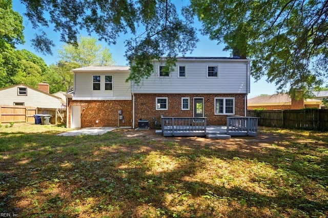 937 Sherry Cir, Newport News, VA 23608 - back of property featuring a lawn, brick siding, central AC, a wooden deck, and a fenced backyard