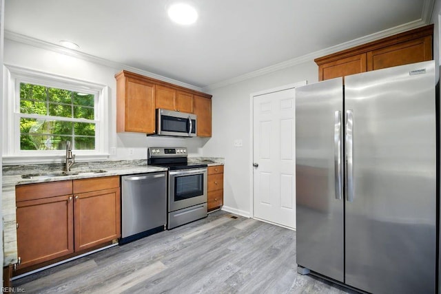 937 Sherry Cir, Newport News, VA 23608 - kitchen with light stone countertops, a sink, crown molding, light wood-style floors, and stainless steel appliances