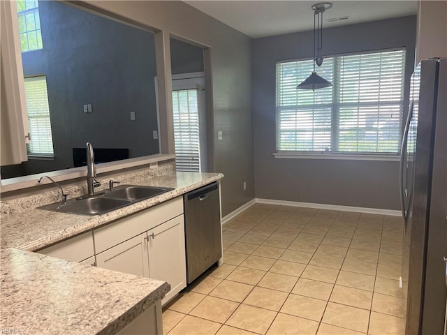 kitchen featuring white cabinetry, appliances with stainless steel finishes, a wealth of natural light, and a sink