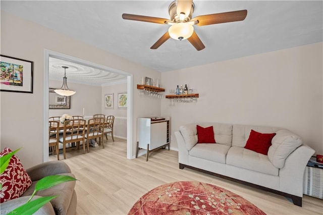 living room with light wood-type flooring and a ceiling fan