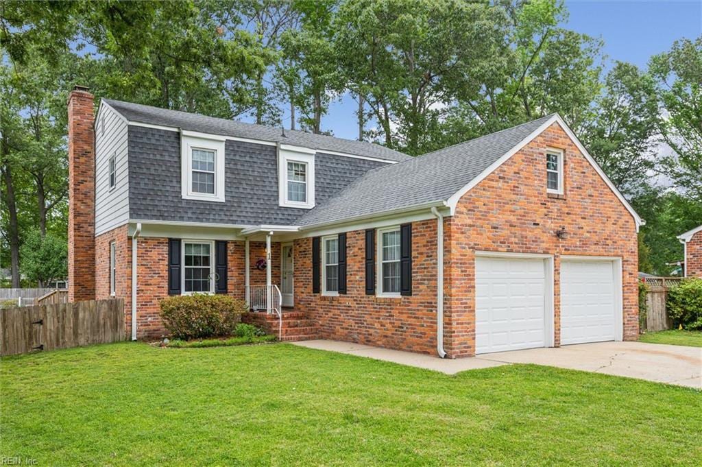 1 Lauren Dr, Poquoson, VA 23662 - colonial inspired home with a chimney, brick siding, concrete driveway, a shingled roof, and a garage