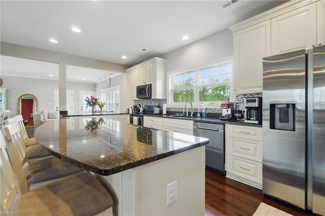 1725 Burson Dr, Chesapeake, VA 23323 - kitchen featuring appliances with stainless steel finishes, a sink, tasteful backsplash, a kitchen bar, and healthy amount of natural light