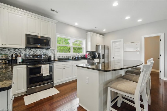 1725 Burson Dr, Chesapeake, VA 23323 - kitchen with appliances with stainless steel finishes, a sink, dark wood-style floors, decorative backsplash, and white cabinetry