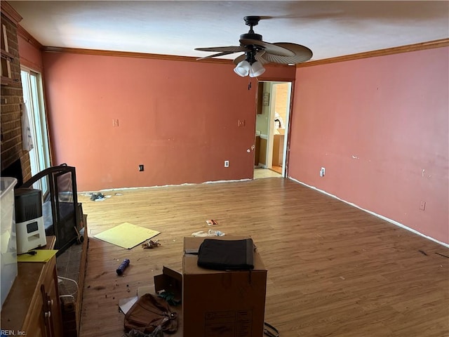 unfurnished living room featuring ornamental molding, a ceiling fan, wood finished floors, and baseboards