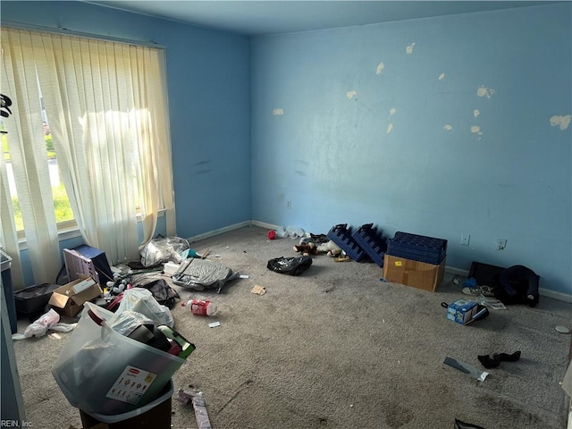 unfurnished room featuring carpet and baseboards