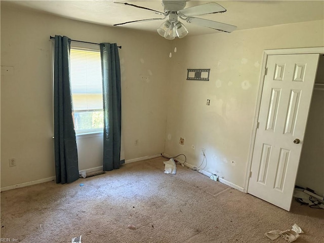 empty room with carpet, ceiling fan, and baseboards