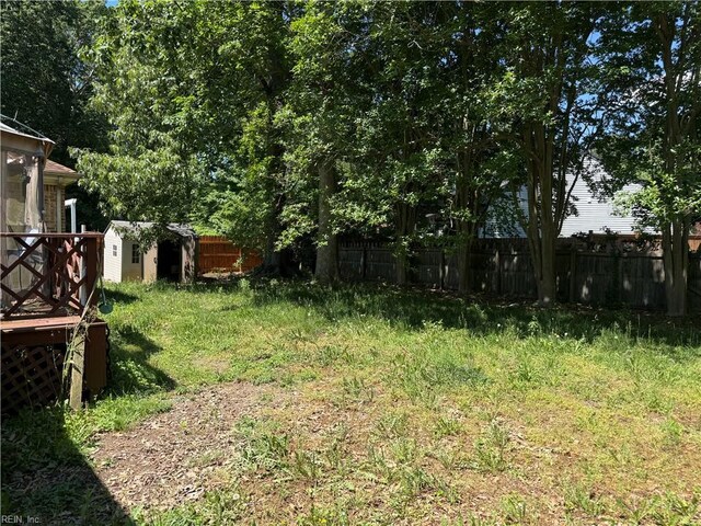 view of yard with a storage shed, fence, and an outbuilding