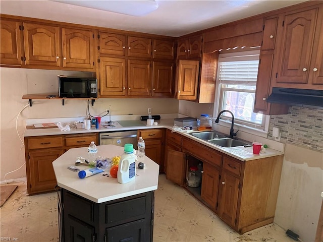 kitchen featuring black microwave, light flooring, a sink, brown cabinetry, and light countertops