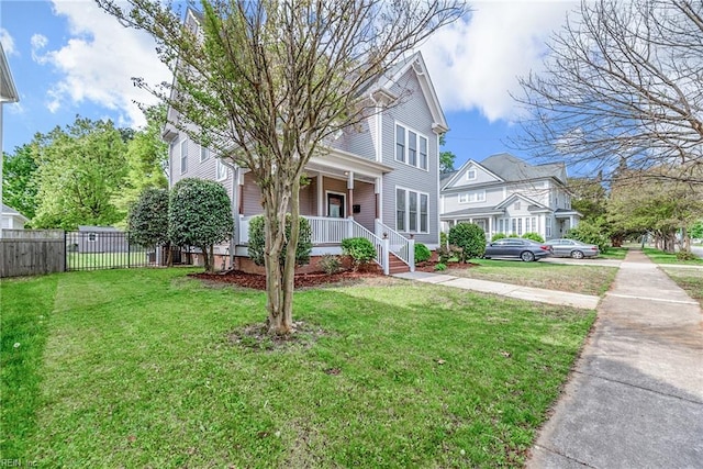 view of front of property with a front lawn, covered porch, and fence