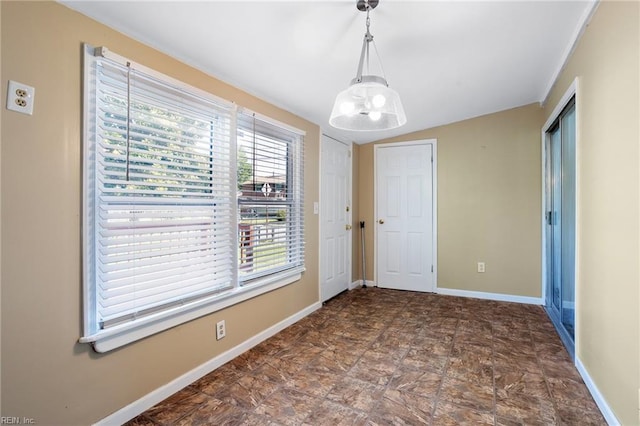 unfurnished room with a chandelier, baseboards, stone finish flooring, and vaulted ceiling