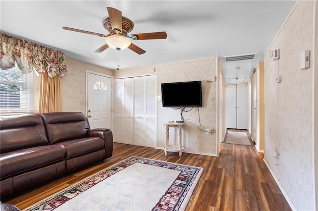 living room featuring ceiling fan, dark wood-type flooring, baseboards, and wallpapered walls