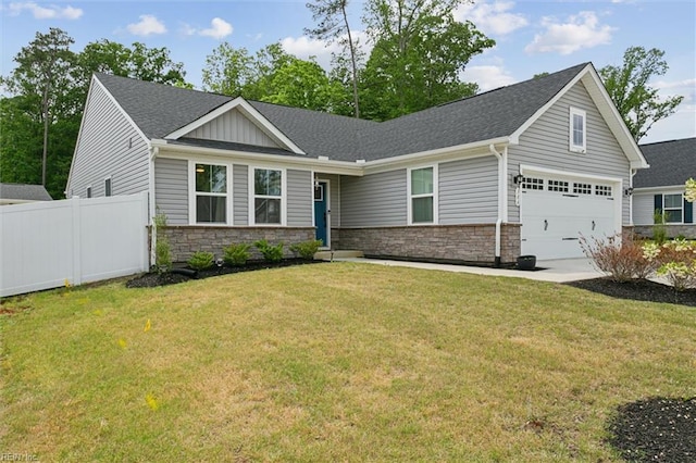 view of front of home featuring stone siding, fence, a shingled roof, a front lawn, and driveway