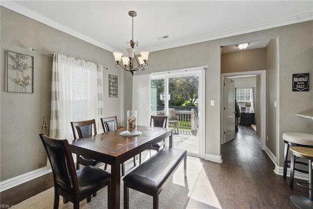 dining room with ornamental molding, a chandelier, visible vents, and wood finished floors