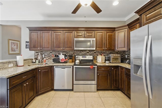 kitchen featuring a sink, stainless steel appliances, backsplash, a ceiling fan, and light tile patterned floors