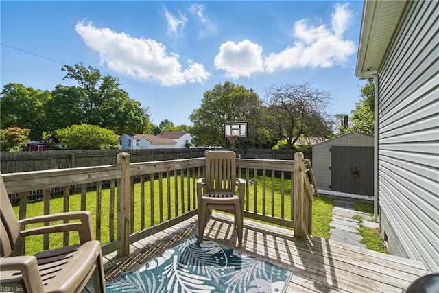 deck with an outdoor structure, a lawn, a fenced backyard, and a storage unit