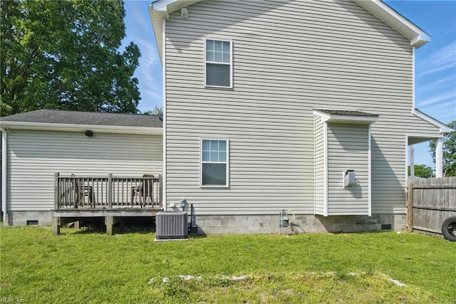back of property with a lawn, fence, crawl space, central AC unit, and a wooden deck