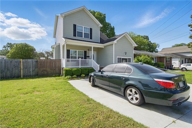 traditional-style house featuring a front lawn, a porch, and fence