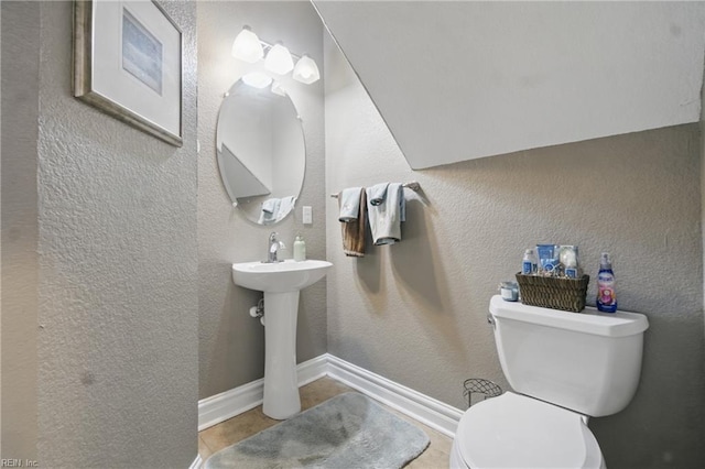 bathroom featuring toilet, tile patterned flooring, and baseboards