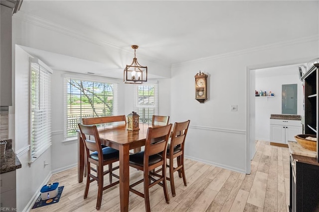 dining room with light wood-style floors, crown molding, a chandelier, baseboards, and electric panel