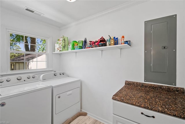 laundry room featuring electric panel, washing machine and clothes dryer, crown molding, light wood-style floors, and baseboards