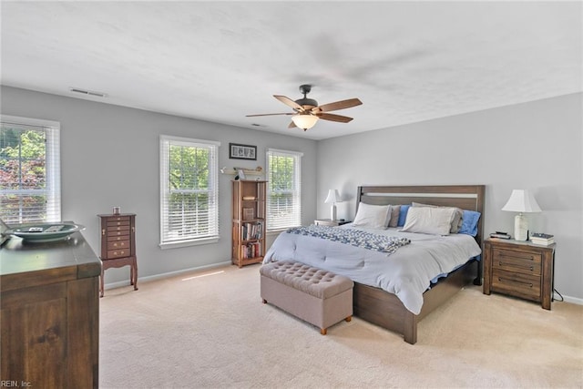 bedroom with light carpet, baseboards, and a ceiling fan