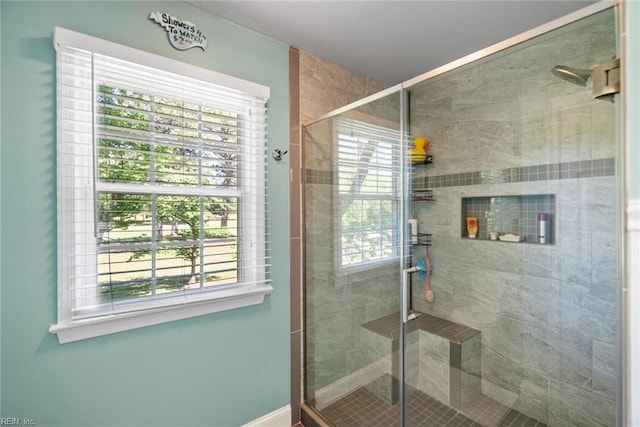full bath with a stall shower, healthy amount of natural light, and baseboards