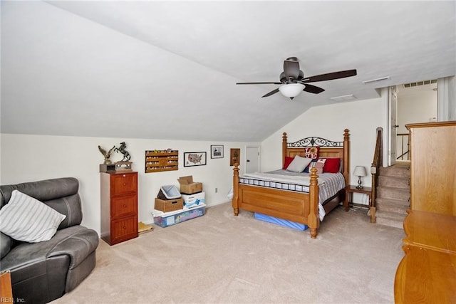 bedroom featuring light colored carpet, vaulted ceiling, and a ceiling fan
