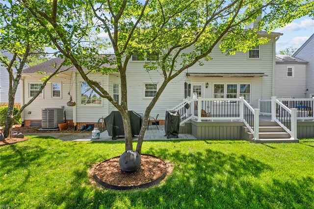 rear view of property featuring central AC, a yard, and a wooden deck